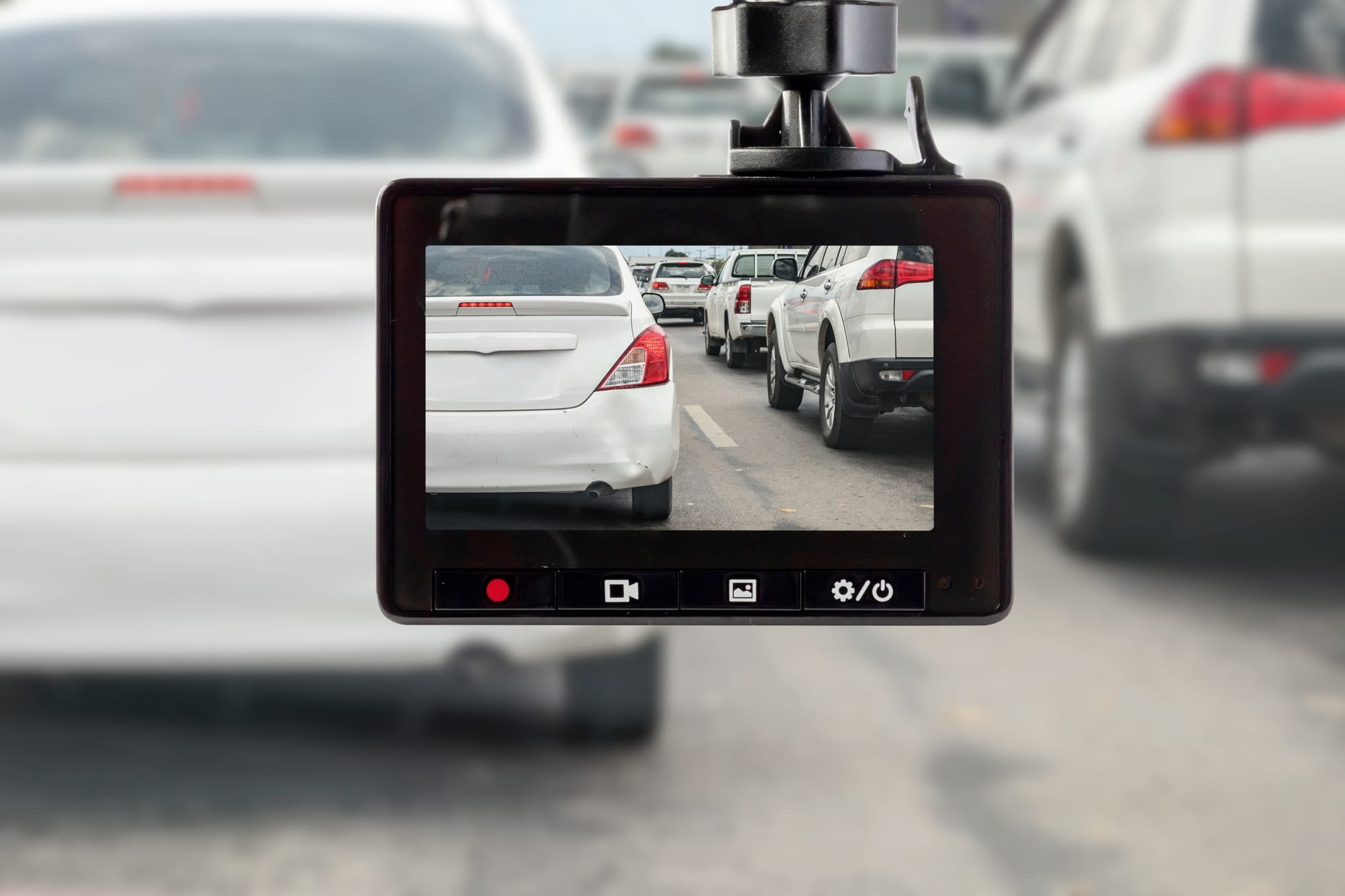 A camera mounted inside a vehicle filming traffic ahead on the highway.